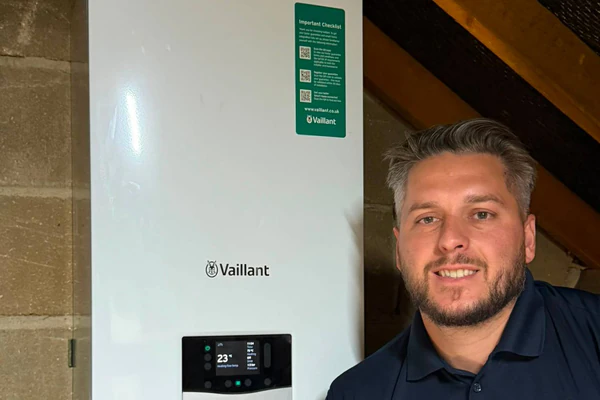 Jordan next to a wall-mounted boiler in a loft.
